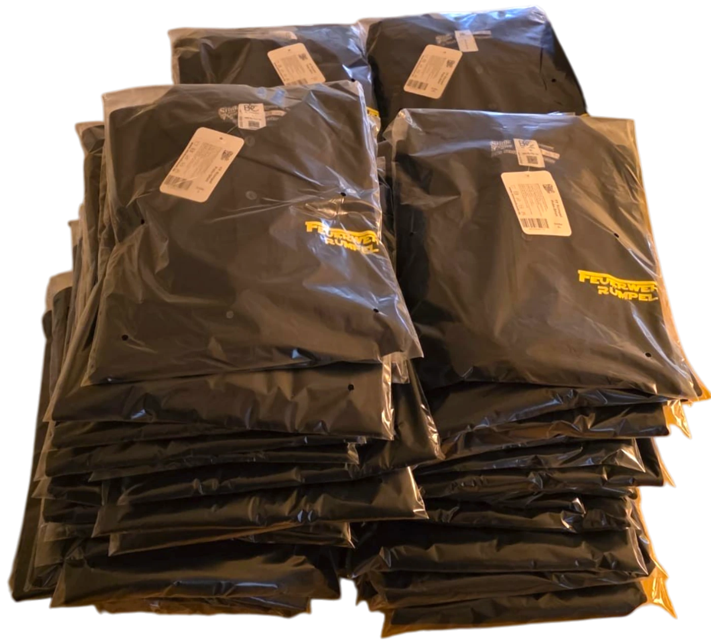 Stapel einzeln in transparenter Folie verpackter schwarzer Textilien